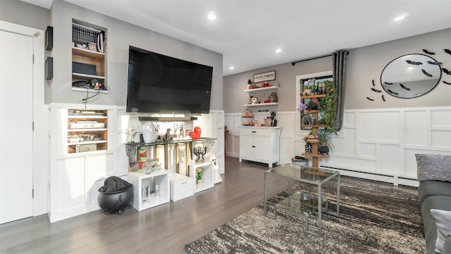 living room with a baseboard heating unit and dark wood-type flooring