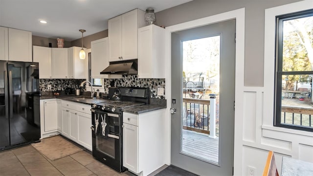 kitchen with tasteful backsplash, white cabinets, hanging light fixtures, and black appliances