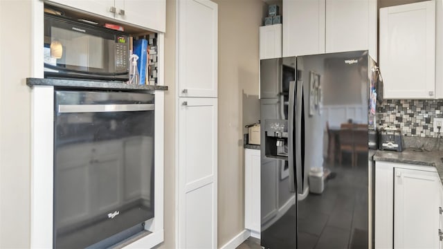 kitchen featuring wine cooler, tasteful backsplash, dark stone countertops, refrigerator with ice dispenser, and white cabinets