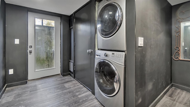 laundry room with stacked washer and dryer and hardwood / wood-style floors