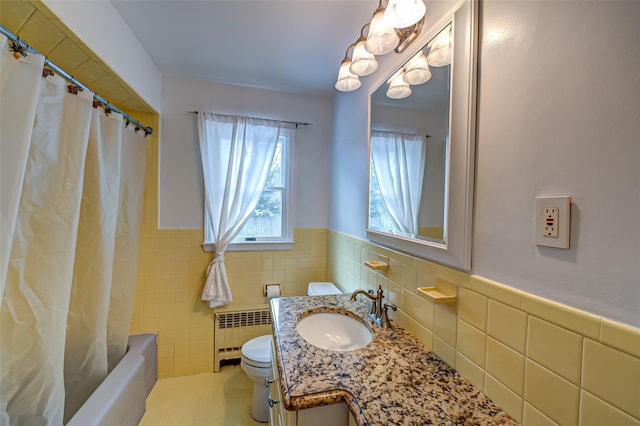 full bathroom featuring vanity, radiator, tile walls, and toilet