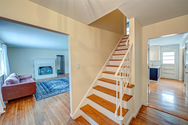 staircase with sink and hardwood / wood-style flooring