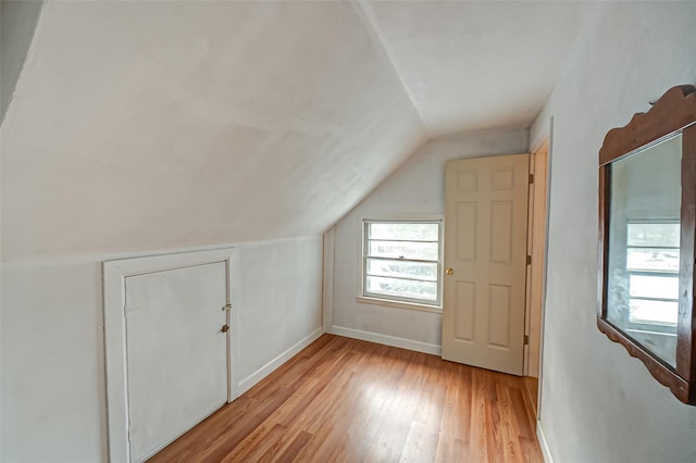 additional living space with lofted ceiling and light hardwood / wood-style flooring