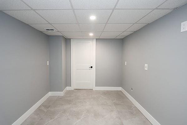 finished below grade area with visible vents, recessed lighting, a paneled ceiling, and baseboards