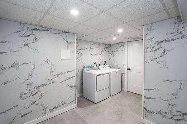 washroom featuring laundry area, recessed lighting, stone wall, and washing machine and clothes dryer