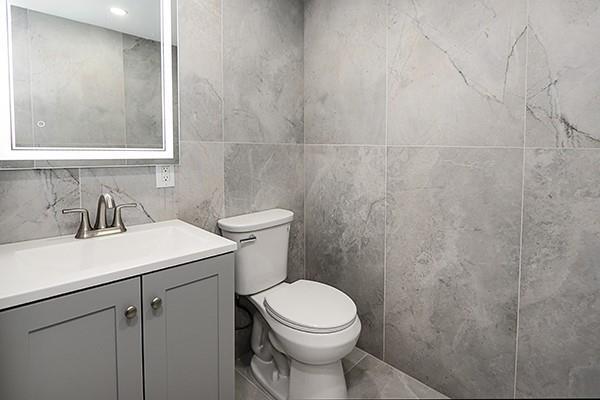 bathroom with toilet, vanity, and tile patterned floors