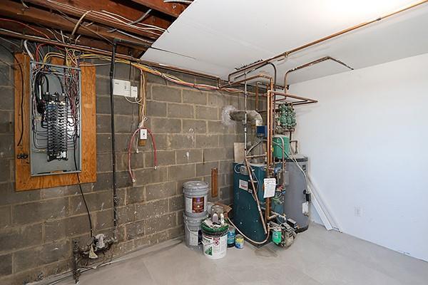 utility room featuring a heating unit and electric panel