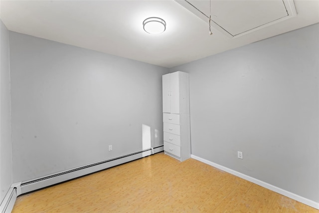 empty room with wood-type flooring and baseboard heating