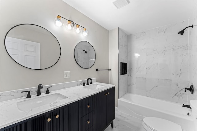 full bathroom with vanity, toilet, and tiled shower / bath