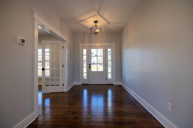 entryway with dark hardwood / wood-style floors and a chandelier