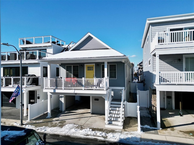 coastal inspired home with covered porch, stairway, and a carport