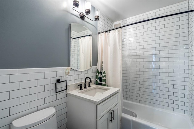 full bathroom featuring vanity, toilet, shower / tub combo, and tile walls