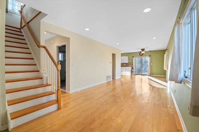 unfurnished living room featuring ceiling fan and light wood-type flooring