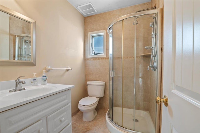 bathroom featuring tile patterned flooring, vanity, an enclosed shower, and toilet