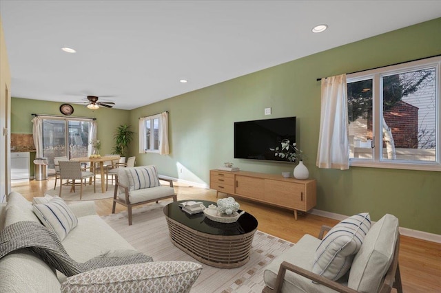 living room with light hardwood / wood-style floors and ceiling fan