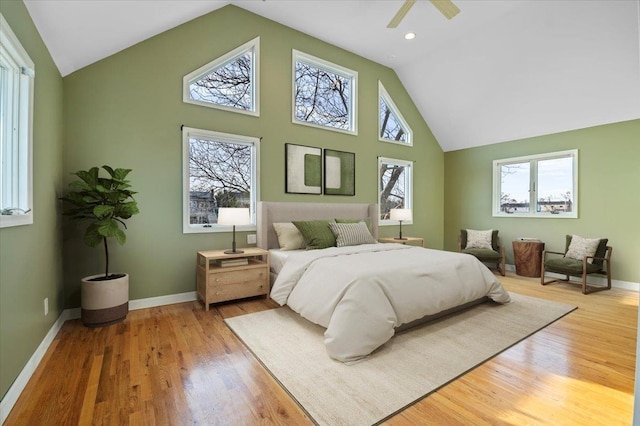 bedroom with wood-type flooring, high vaulted ceiling, and ceiling fan