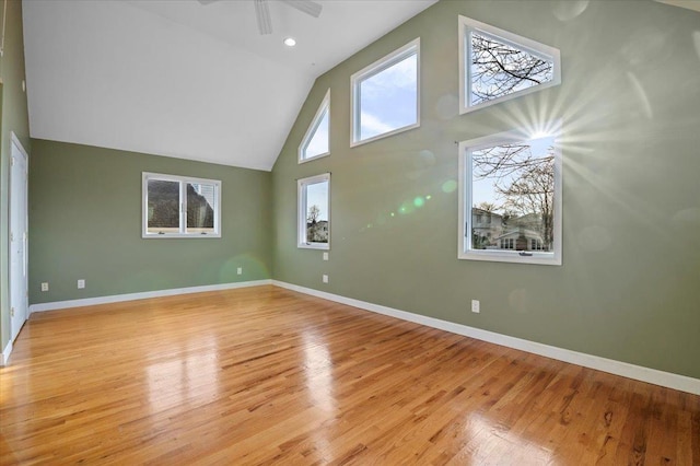 unfurnished living room featuring ceiling fan, high vaulted ceiling, and light wood-type flooring