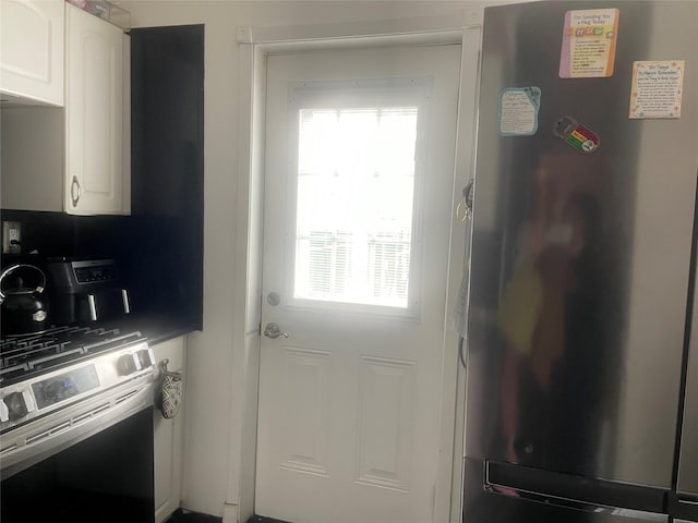 kitchen with stainless steel refrigerator, white cabinetry, and wall oven