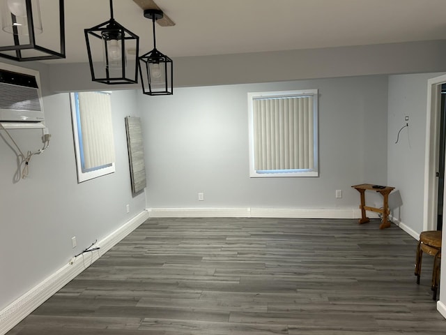 unfurnished dining area featuring dark hardwood / wood-style floors and a wall mounted air conditioner