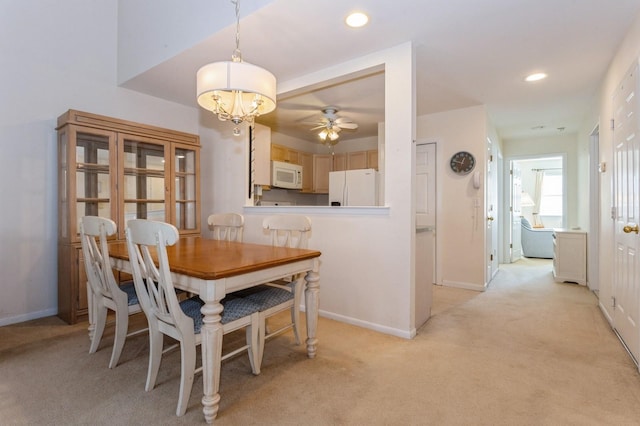 carpeted dining area with ceiling fan