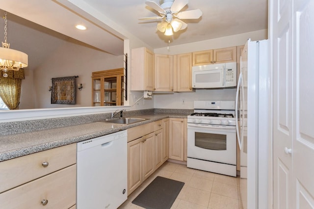 kitchen featuring sink, hanging light fixtures, light tile patterned floors, white appliances, and ceiling fan with notable chandelier