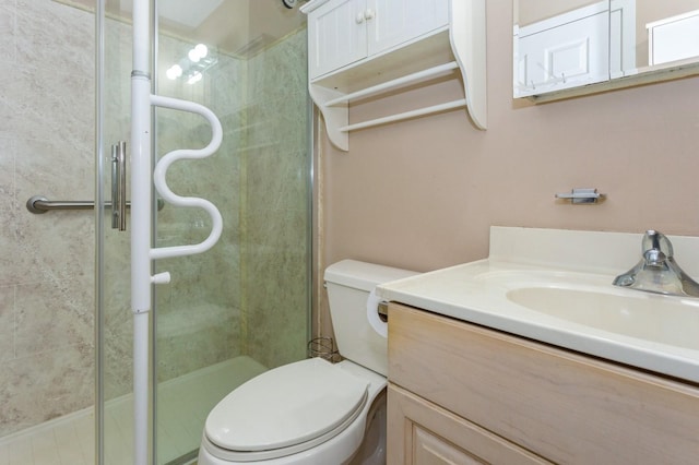 bathroom with a shower with door, vanity, and toilet