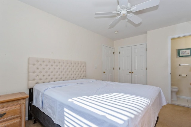 bedroom featuring ensuite bathroom, light colored carpet, ceiling fan, and a closet