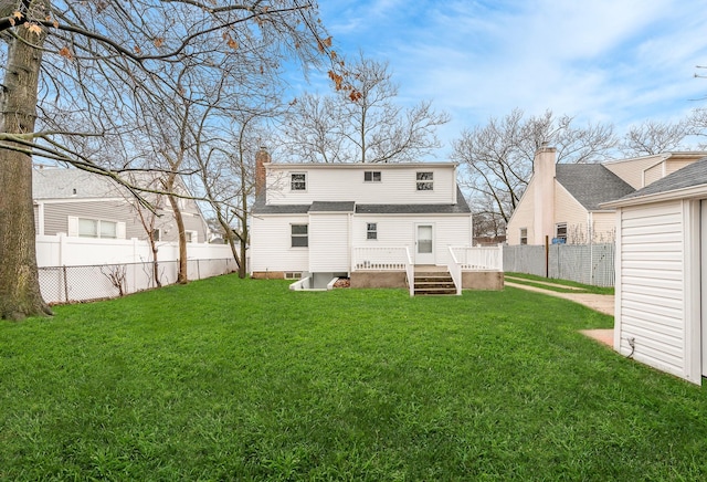 back of property with a wooden deck and a lawn