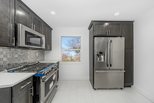 kitchen featuring high quality appliances, light stone countertops, dark brown cabinets, and decorative backsplash