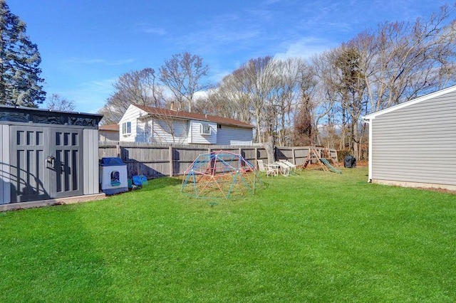 view of yard featuring a storage unit and a playground