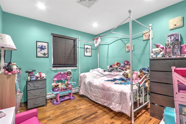 bedroom with a baseboard radiator and wood-type flooring