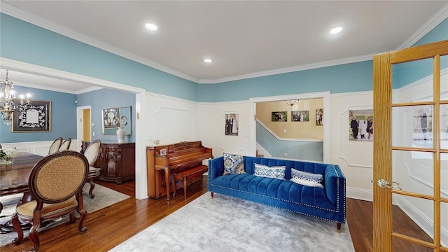 living room featuring an inviting chandelier, dark hardwood / wood-style flooring, and crown molding