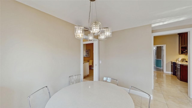 dining area with light tile patterned flooring and an inviting chandelier