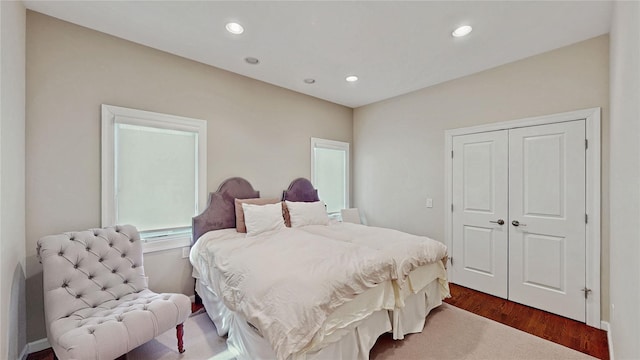 bedroom with dark wood-type flooring and a closet