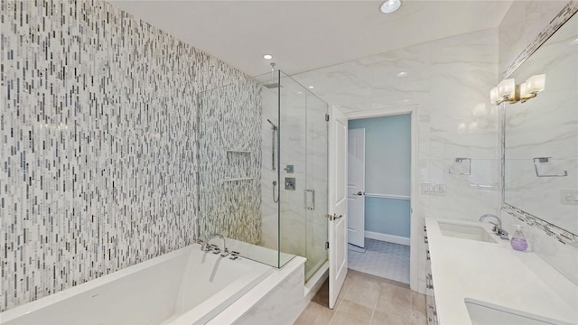 bathroom with vanity, plus walk in shower, tile patterned flooring, and tile walls