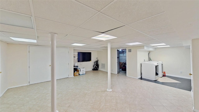 basement featuring separate washer and dryer and a drop ceiling