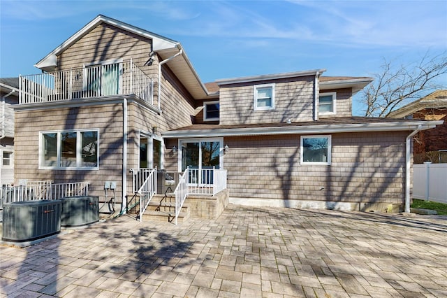 rear view of property with central AC, a balcony, and a patio