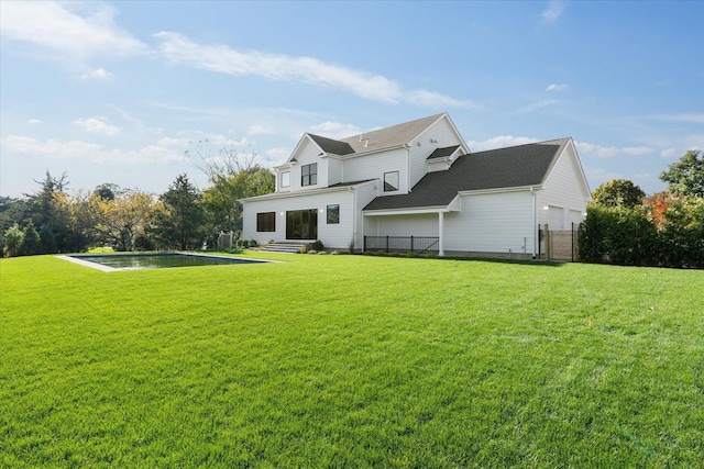 rear view of house featuring a yard