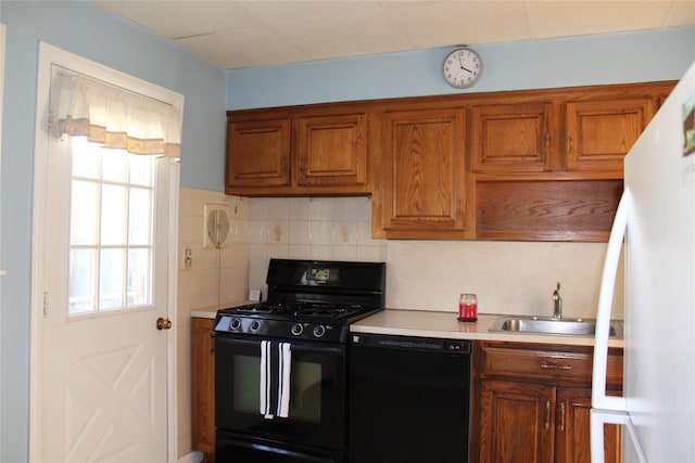 kitchen with backsplash, sink, and black appliances