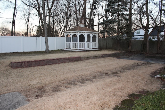 yard at dusk with a gazebo