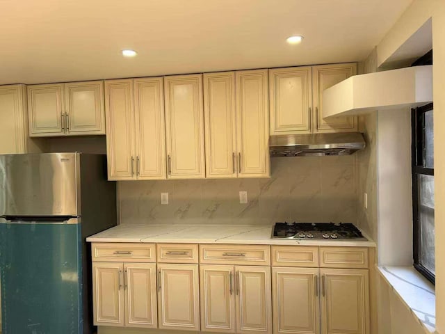 kitchen with tasteful backsplash, cream cabinetry, and appliances with stainless steel finishes