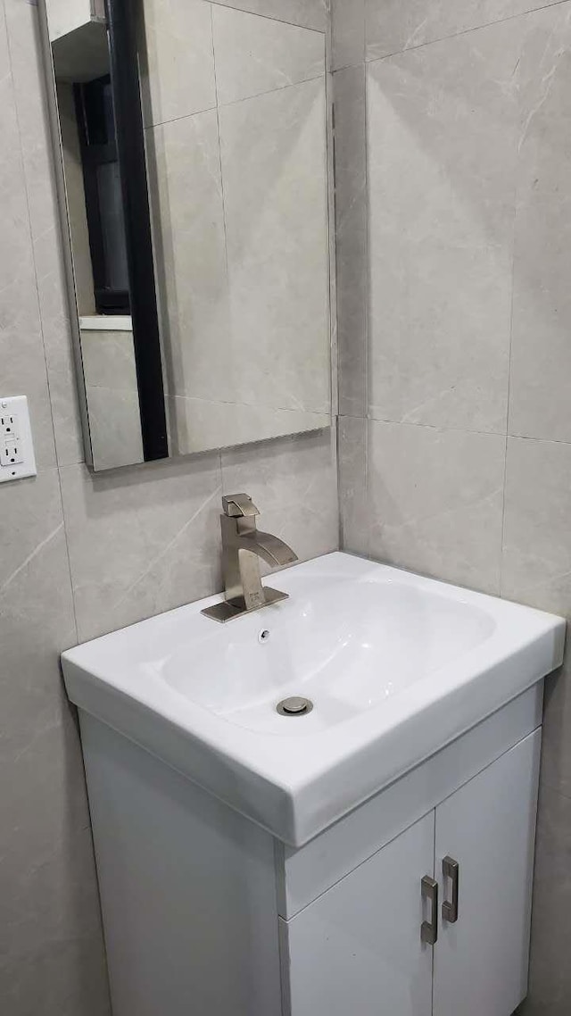 bathroom with vanity, tile walls, and decorative backsplash