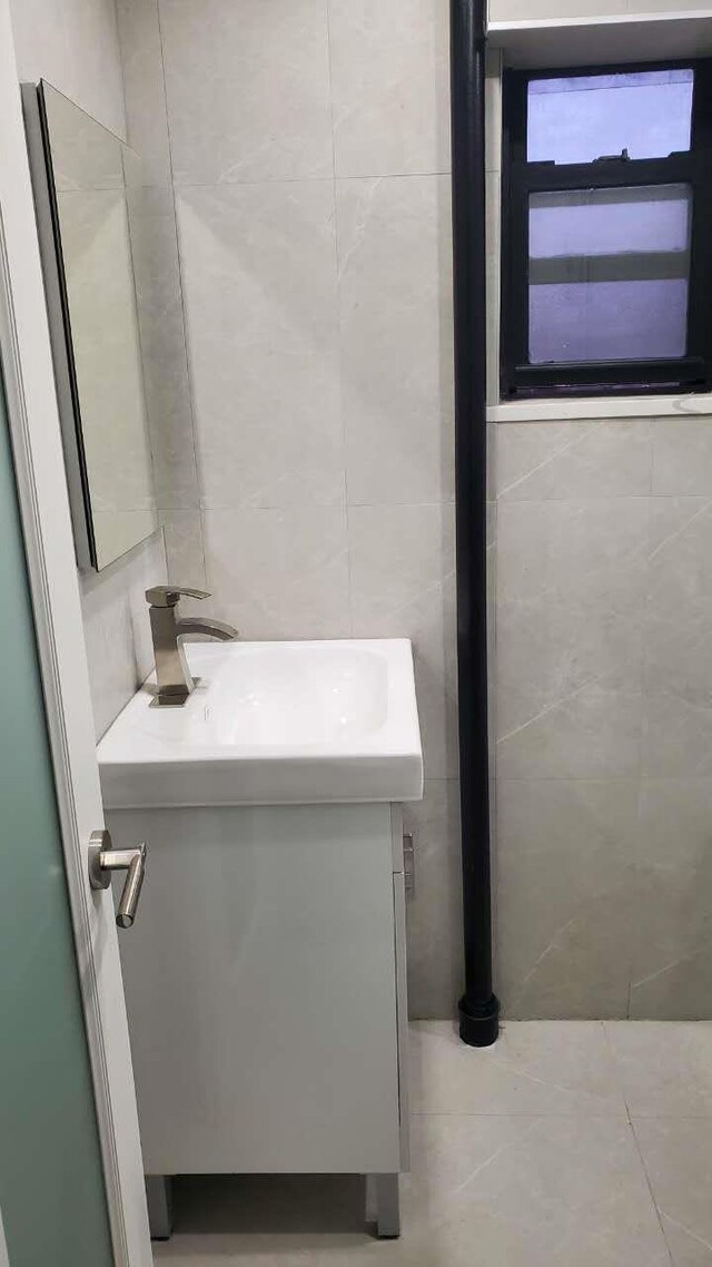 bathroom with tile walls and vanity