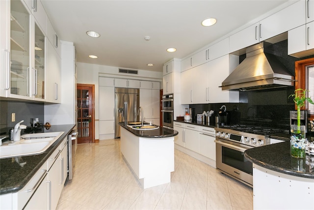 kitchen with sink, stainless steel appliances, ventilation hood, white cabinets, and a kitchen island