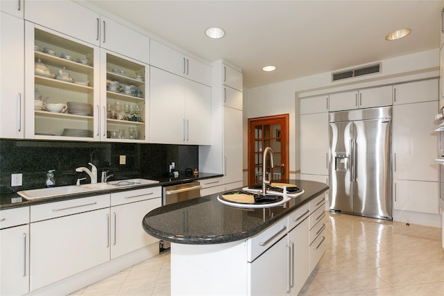 kitchen featuring white cabinetry, appliances with stainless steel finishes, sink, and a center island