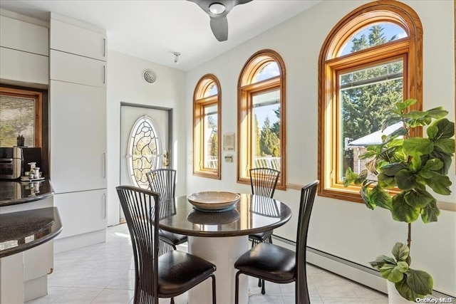 dining space with a baseboard radiator, light tile patterned floors, and ceiling fan