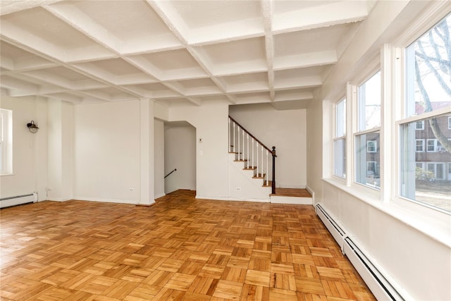 empty room with baseboards, coffered ceiling, a baseboard radiator, stairway, and beamed ceiling