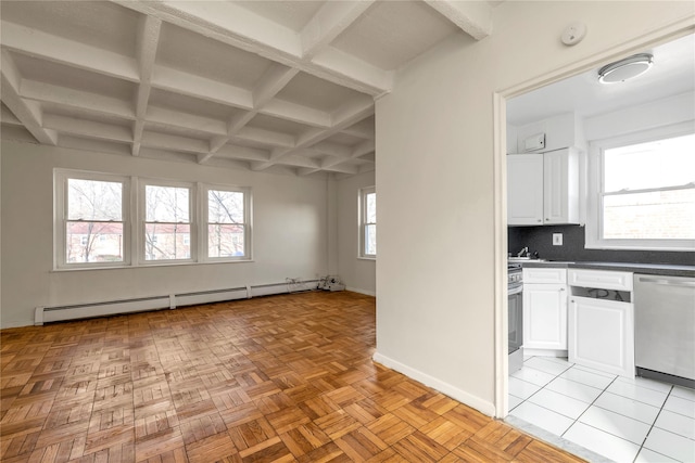 interior space featuring tasteful backsplash, baseboards, white cabinets, a baseboard radiator, and appliances with stainless steel finishes