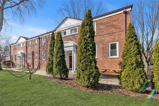 view of front of property with brick siding and a front yard