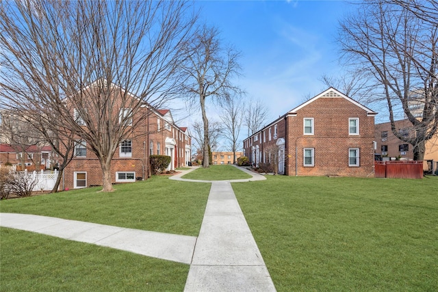 view of community with a yard and fence